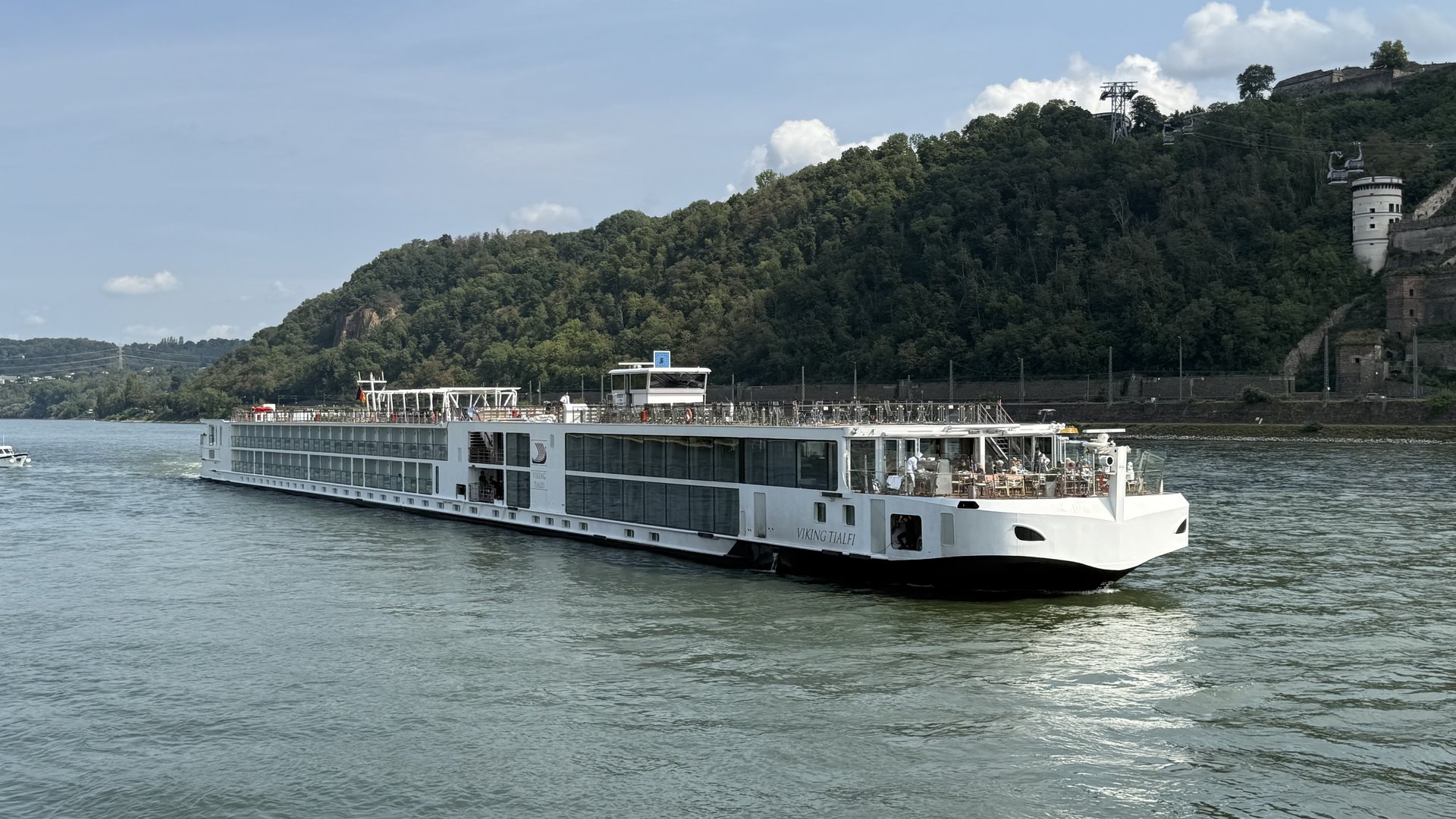 Viking Tialfi river ship sailing the Rhine past a forested hillside